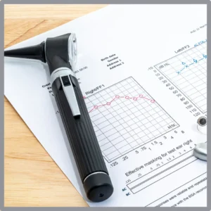 An otoscope rests on top of audiogram.
