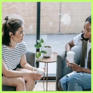 Two women talk over coffee.