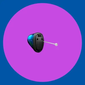 A black ITE hearing aid sits on a purple background. 