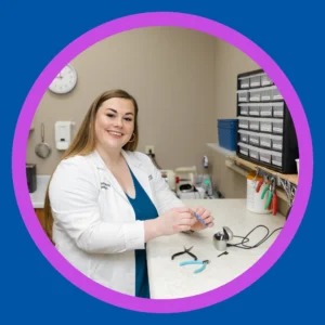 An audiologist smiles in her office. 