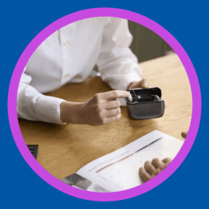 An audiologist shows rechargeable hearing aids. 