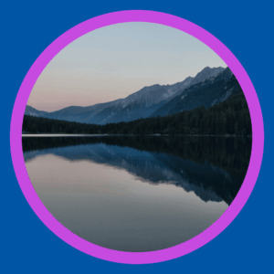 A lake has mountains behind it. 