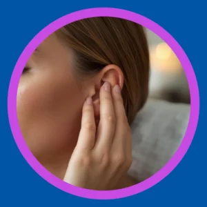 A woman massages her ear.