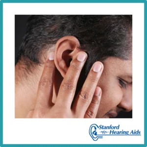 A man touches his ear uncomfortably. 