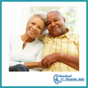 An older couple cuddles and smiles. 