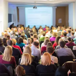 People attend a conference in a large hall. 