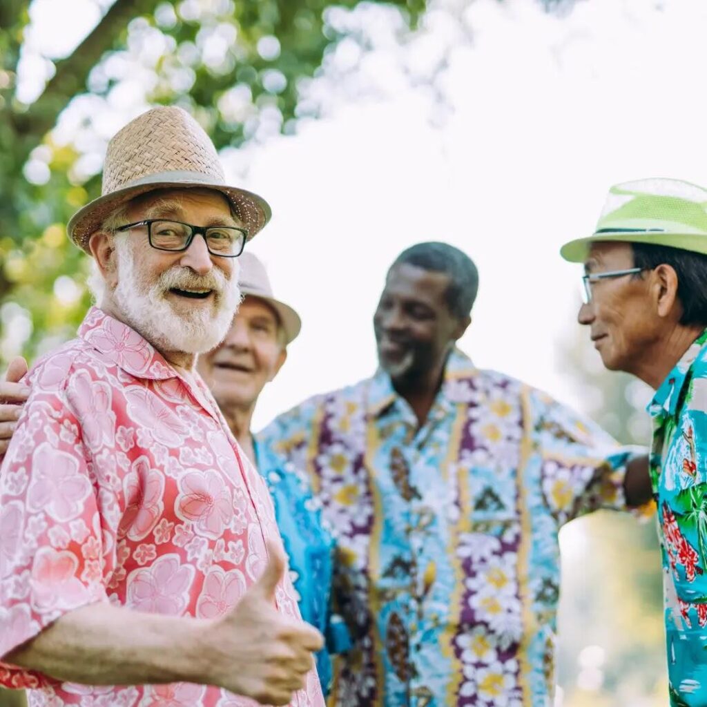 Older men in festive shirts chat outside.