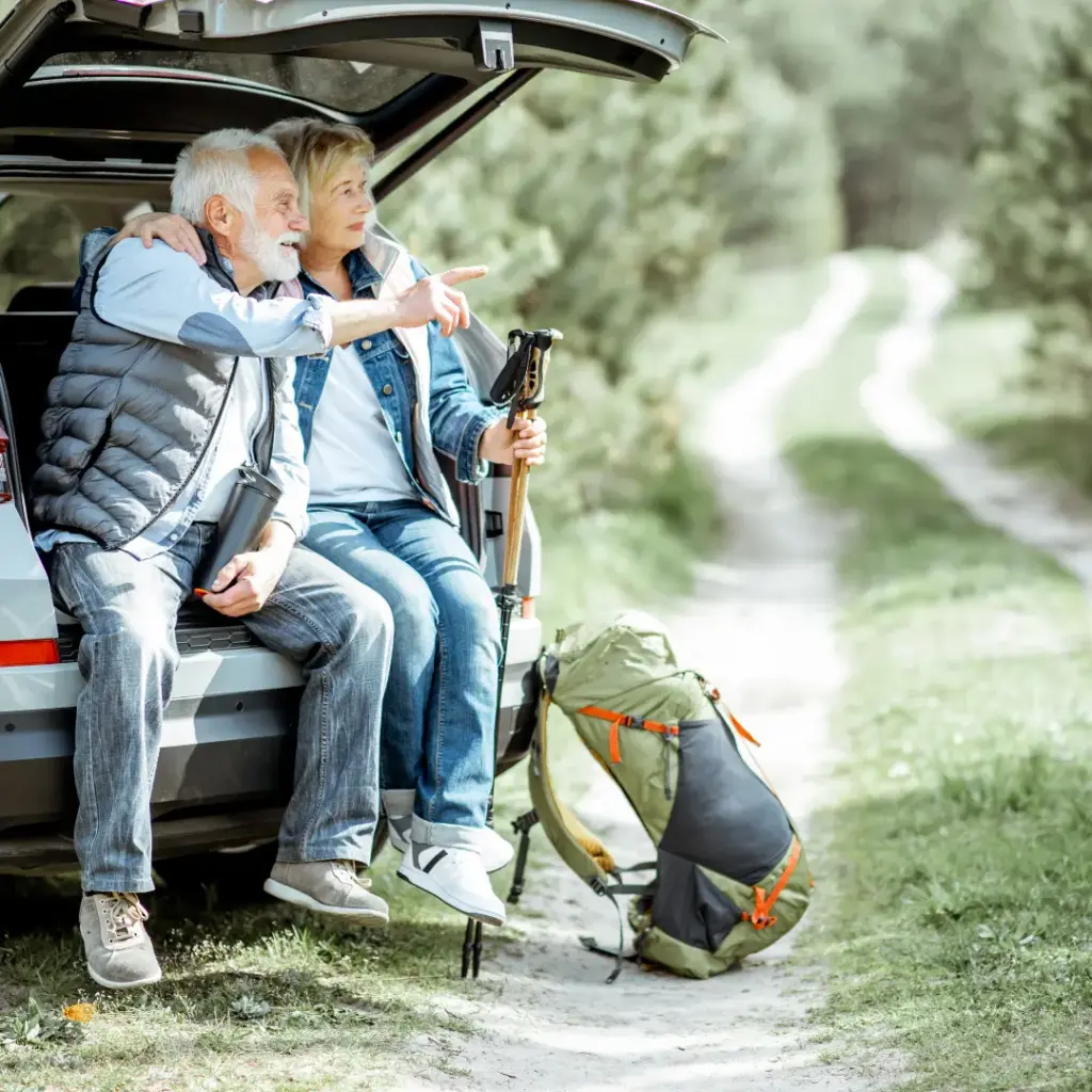 An older couple sits before starting a hike.
