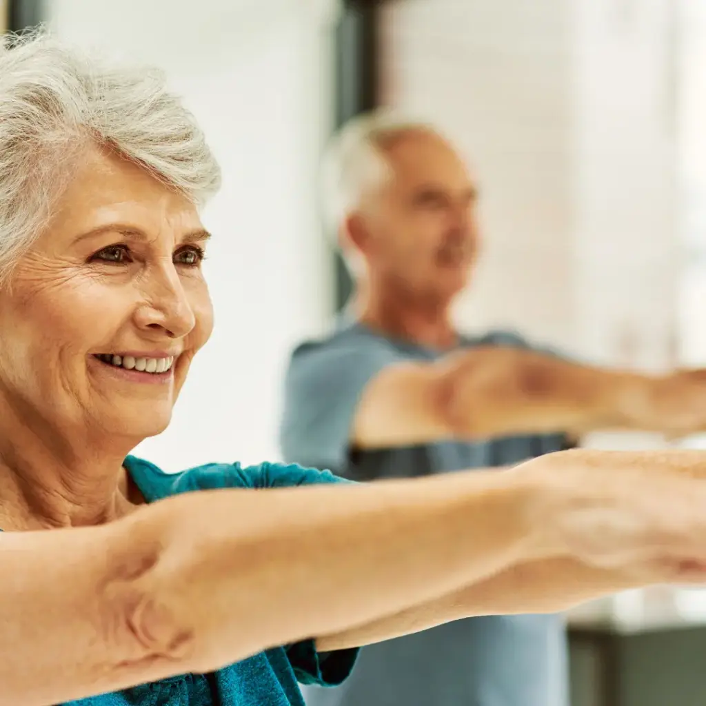 An older couple does yoga together.