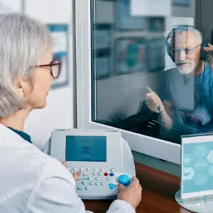 An audiologist tests a man’s hearing. 