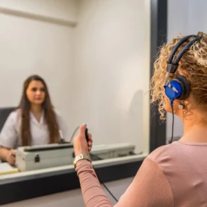An audiologist gives a hearing test to a patient.