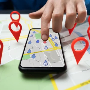 A finger points to a map of locations on a cell phone. 
