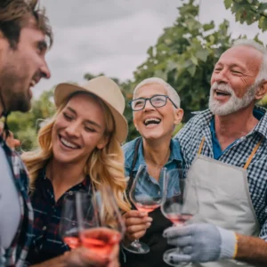 Two couples drink wine outside. 