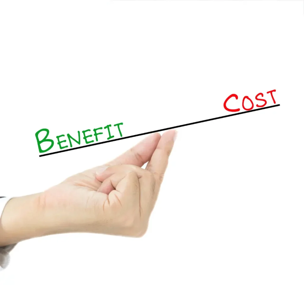 A hand holds a balance scale with “benefits” on one side and “costs” on the other.