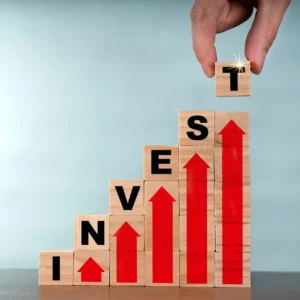 Stacks of blocks spell “invest” with red arrows going up.