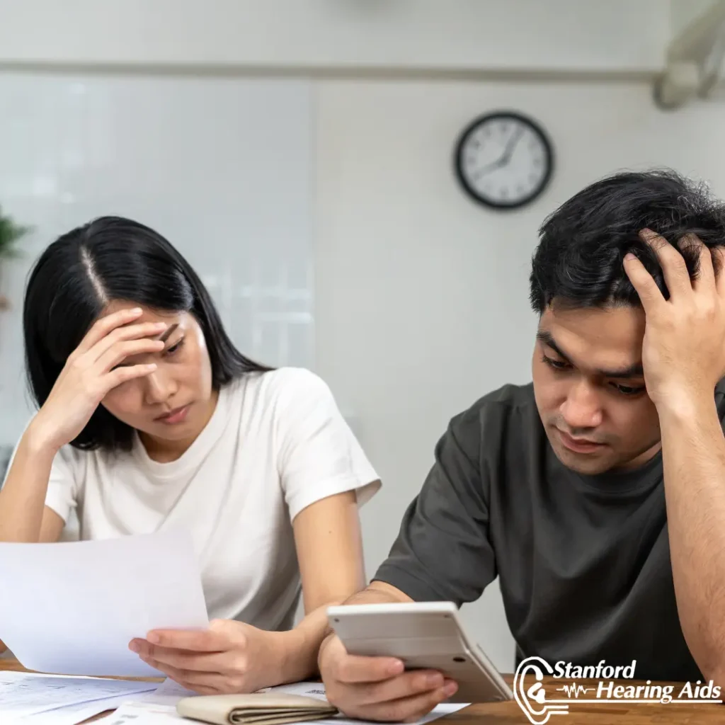 A couple looks over their insurance paperwork unhappily.