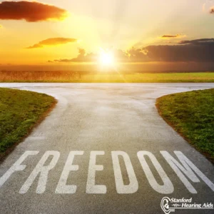 A road branches off through a field. The word “Freedom” is painted on the road.