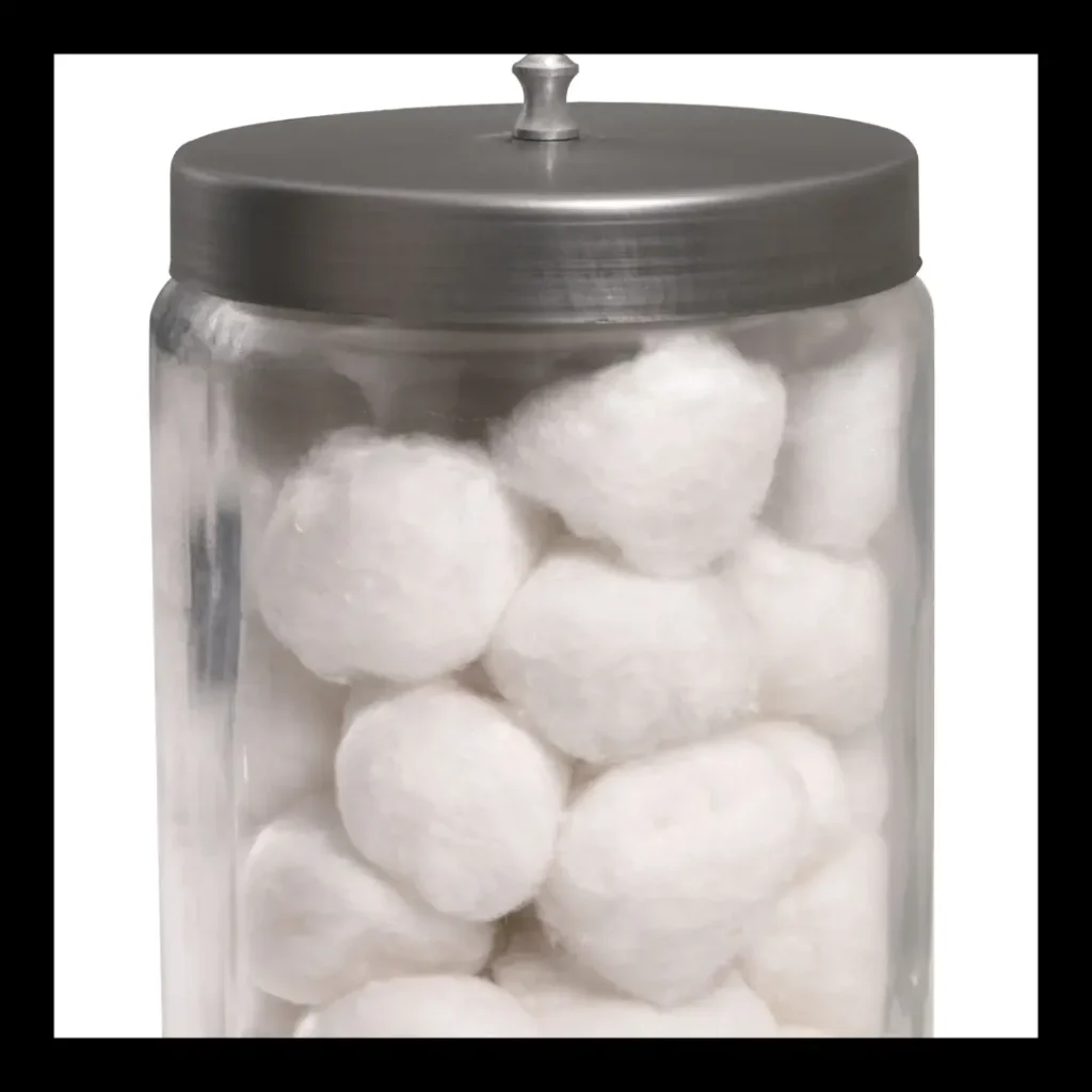 A jar of cotton balls stands on a white background.