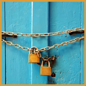 Padlocks and chains cover a blue door. 