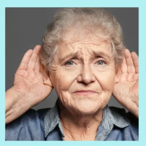 An older woman cups her hands around her ears as if she can’t hear. 