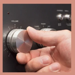 A hand turns a volume dial up. 