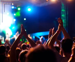 People clapping their hands at a concert. 