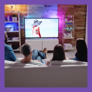 Four friends sit on a couch watching a movie. 