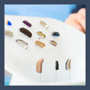 A display of an array of hearing aid receivers sits on a white table. 