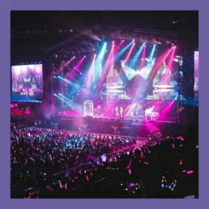 A band plays in front of a huge audience at an arena.