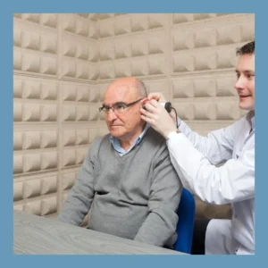 An audiologist examines an older man’s ear. 