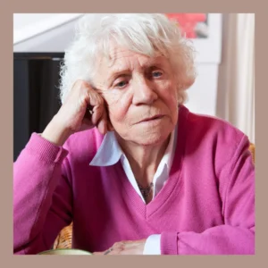 An older woman sits and looks very depressed. 