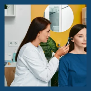 An audiologist looks in her patient's ear. 