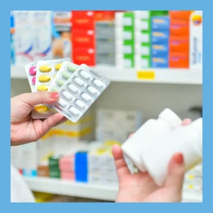 Hands hold several different kinds of pills in a pharmacy. 