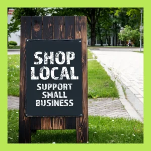 A wooden outdoor sign says, “Shop Local. Support Small Business.” 