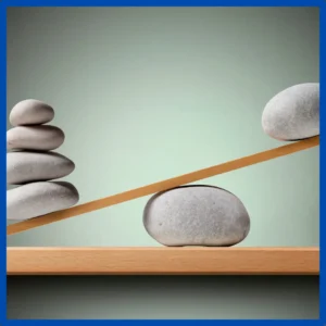 A balance scale shows rocks holding down one side and one rock sits on the high sid