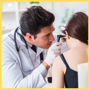 An audiologist checks a woman's hearing.