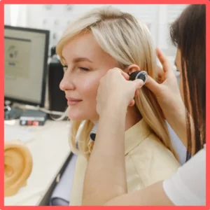 An audiologist examines a woman's ear. 