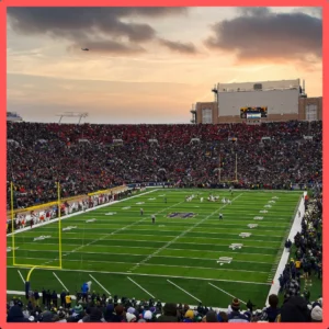 A full football stadium stands at sunset. 