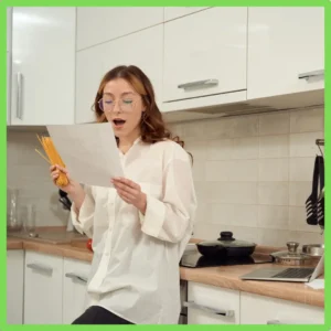 A woman reads aloud in her kitchen. 