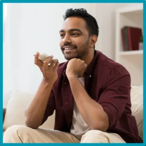 A man smiles while talking into his cell phone.