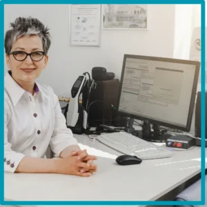 A hearing specialist sits at her desk. 