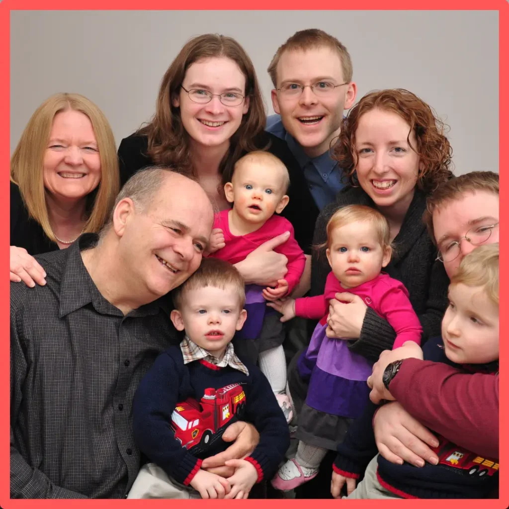 An extended family poses together with young kids.
