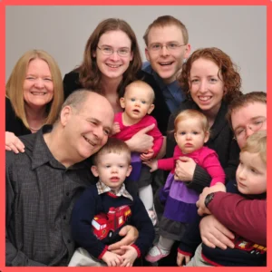 An extended family poses together with young kids.