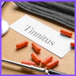 A card that says, "tinnitus" sits on a table next to ear plugs.