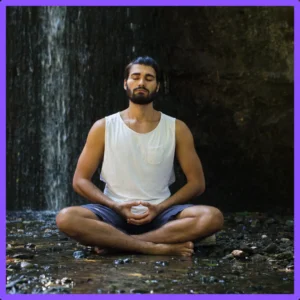 A man meditates in the forest. 