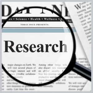 A magnifying highlights the word "research" in a paper. 