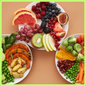 Plates of fruits and vegetables sit on a table. 