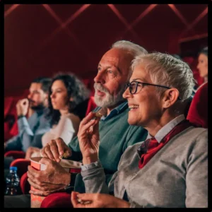 Friends watch a movie at the theater. 