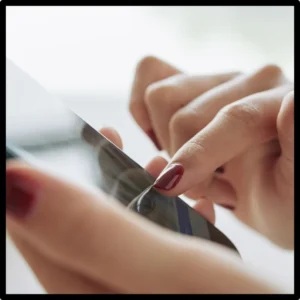 Hands use an app on a cell phone. 