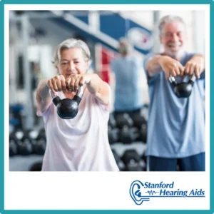 Older people lift kettleballs in a gym. 